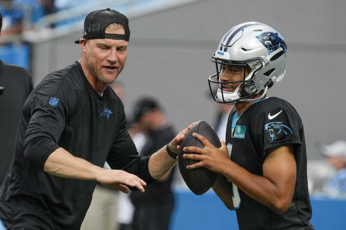 Quarterbacks Coach Josh McCown talks to quarterback Bryce Young while putting his hands out